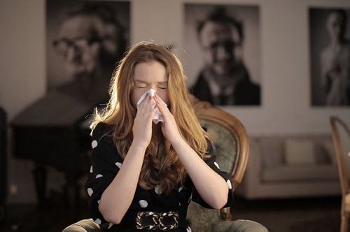 young woman sneezing